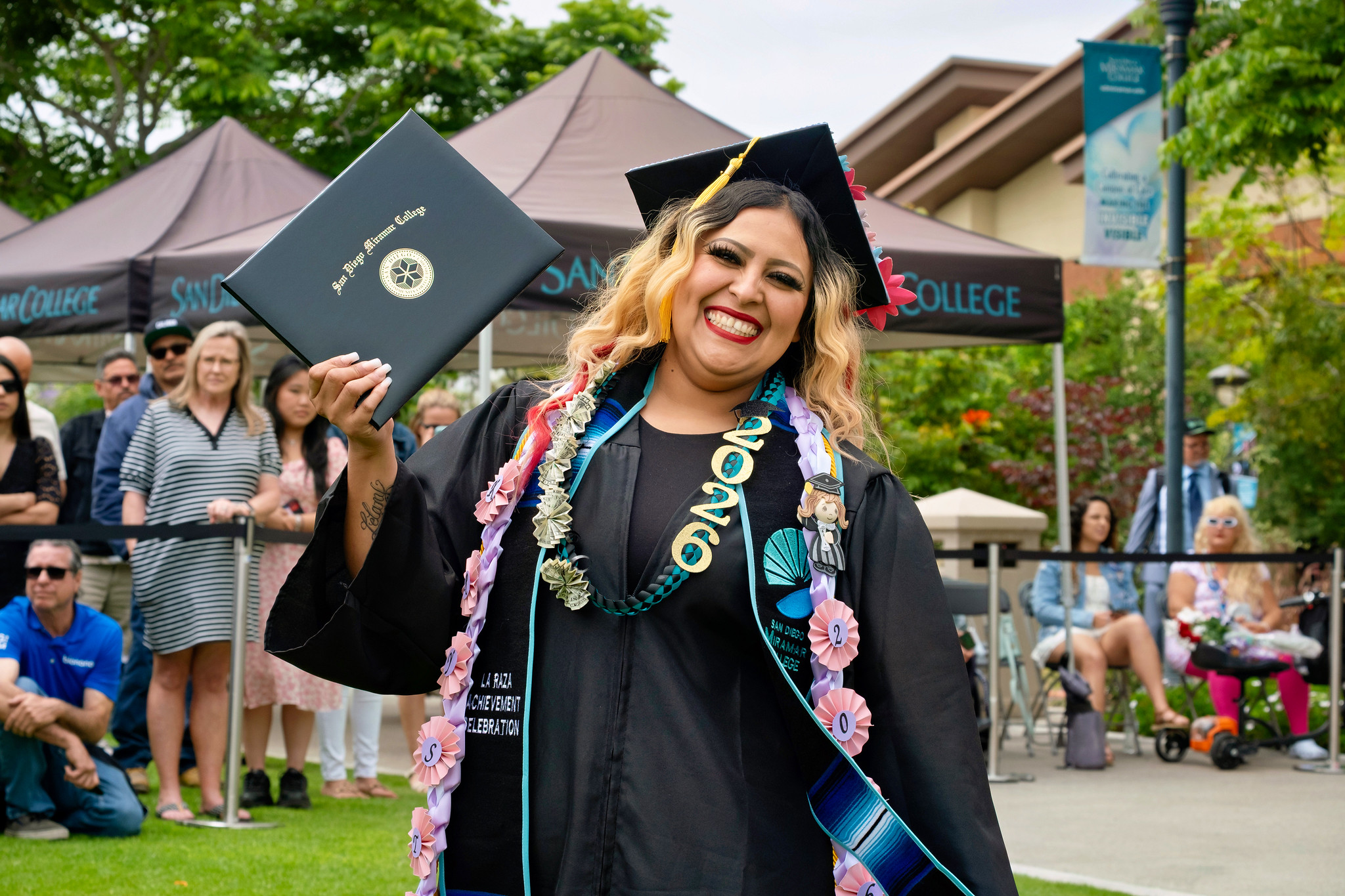 A student holds up their degree.
