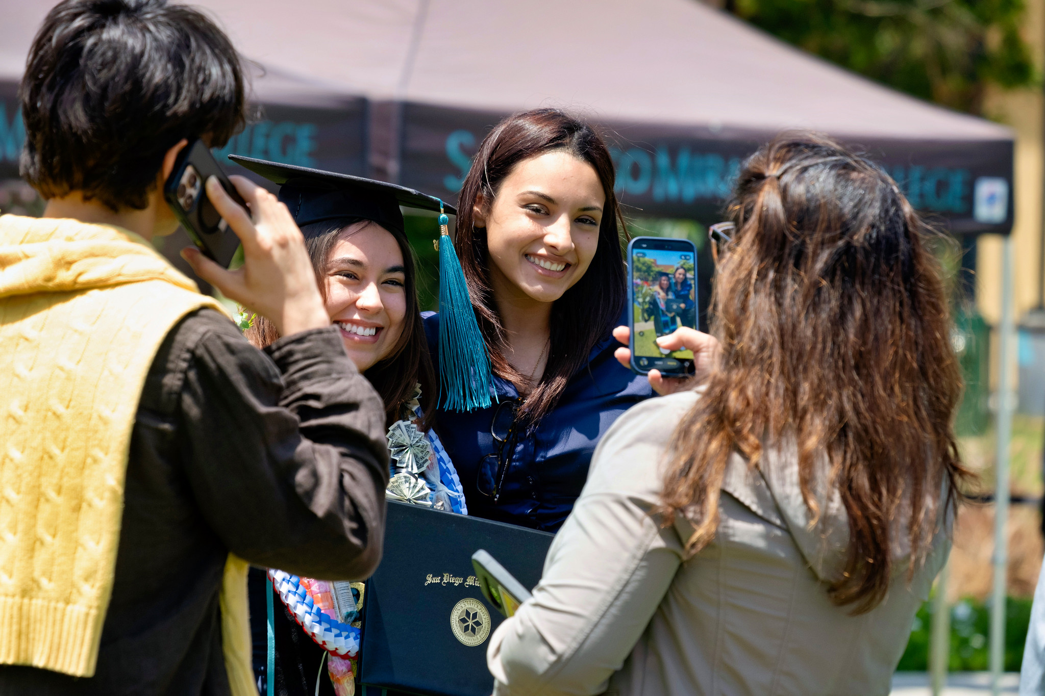 A graduate taking photos with family members.&nbsp;