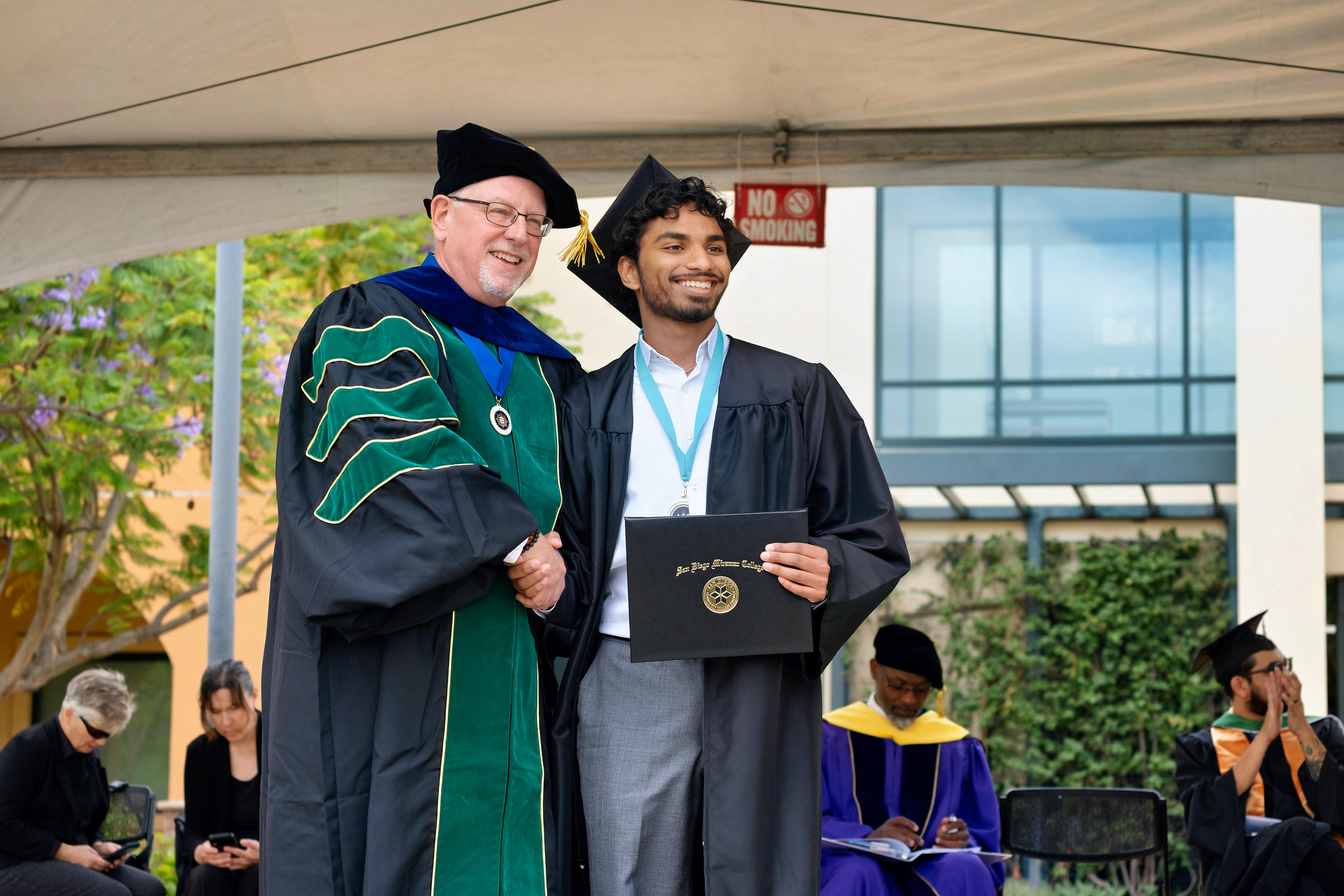 Miramar President Wes Lundburg hands a degree to a graduate.&nbsp;
