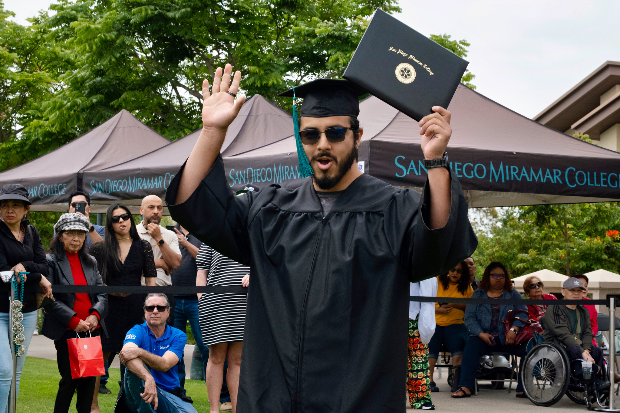 A student holds up their degree.