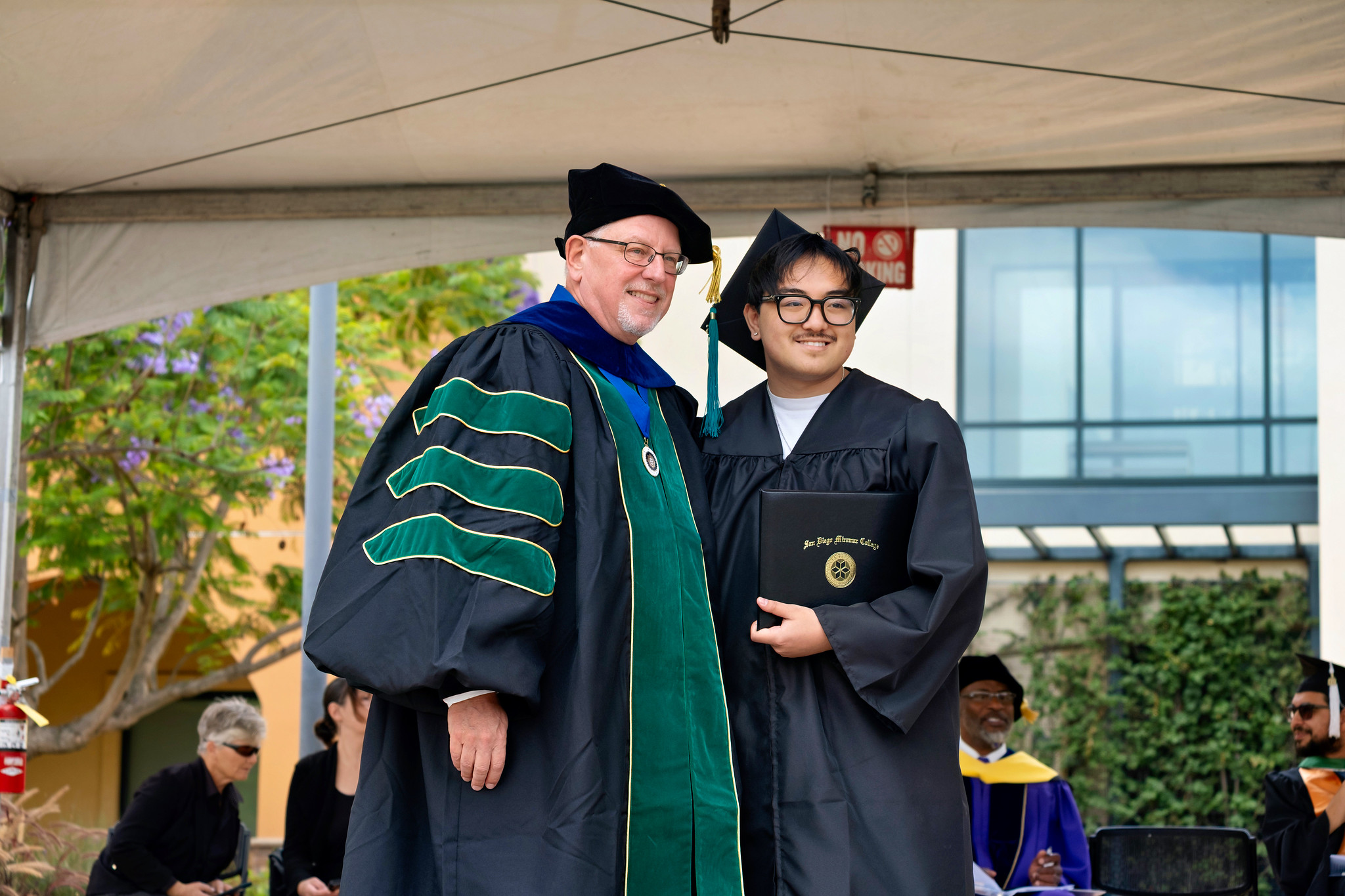 Miramar President Wes Lundburg hands a degree to a graduate.&nbsp;