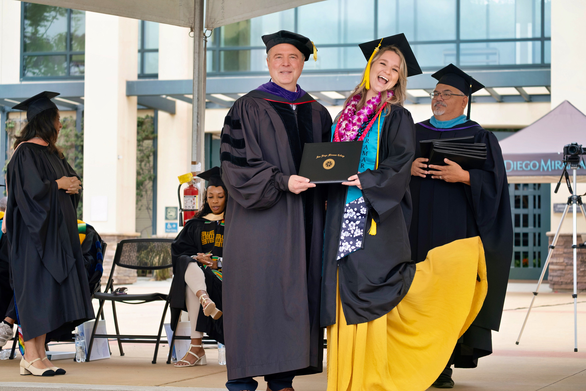 U.S. Senator Adam Schiff hands a degree to a graduate.