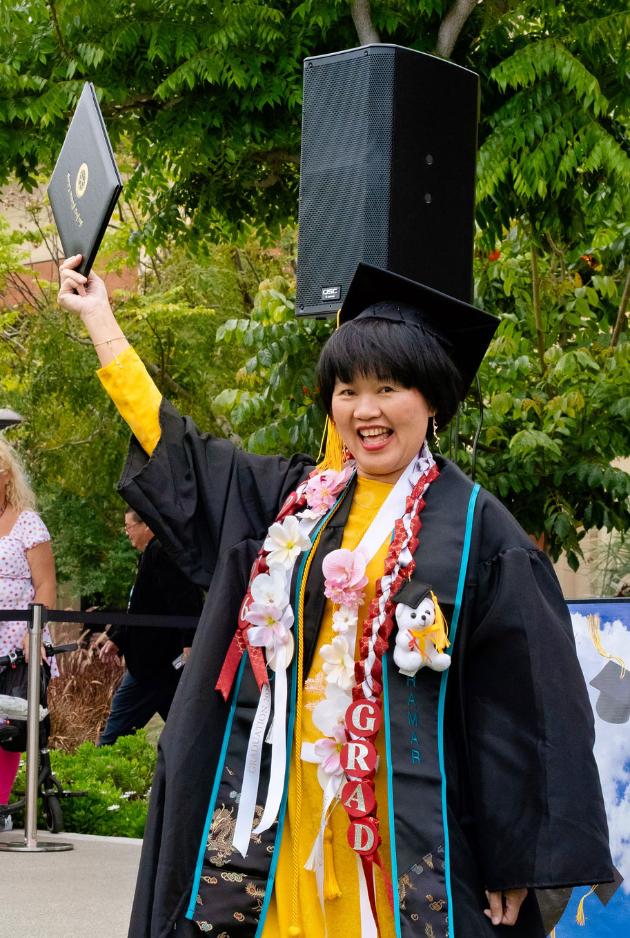 A student holds up their degree.