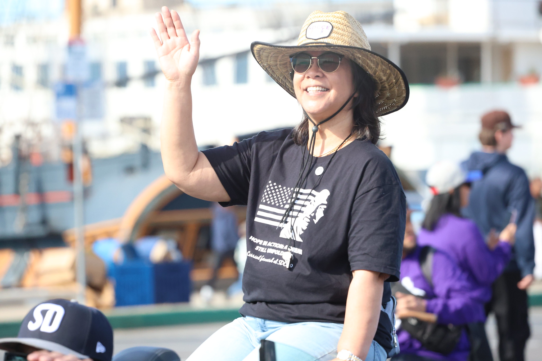 Trustee Marichu Magaña waves from a convertible car in the parade.