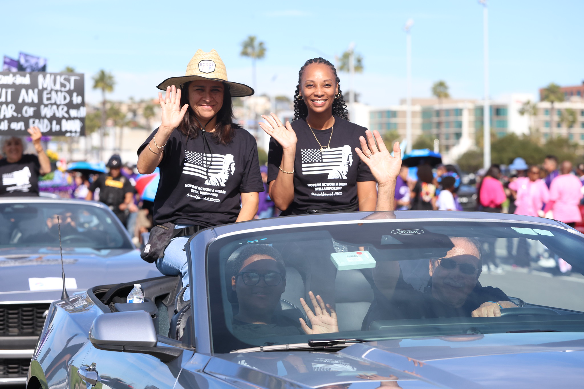 Trustees Geysil Arroyo and Mariah Jameson wave while riding in a convertible in the parade.