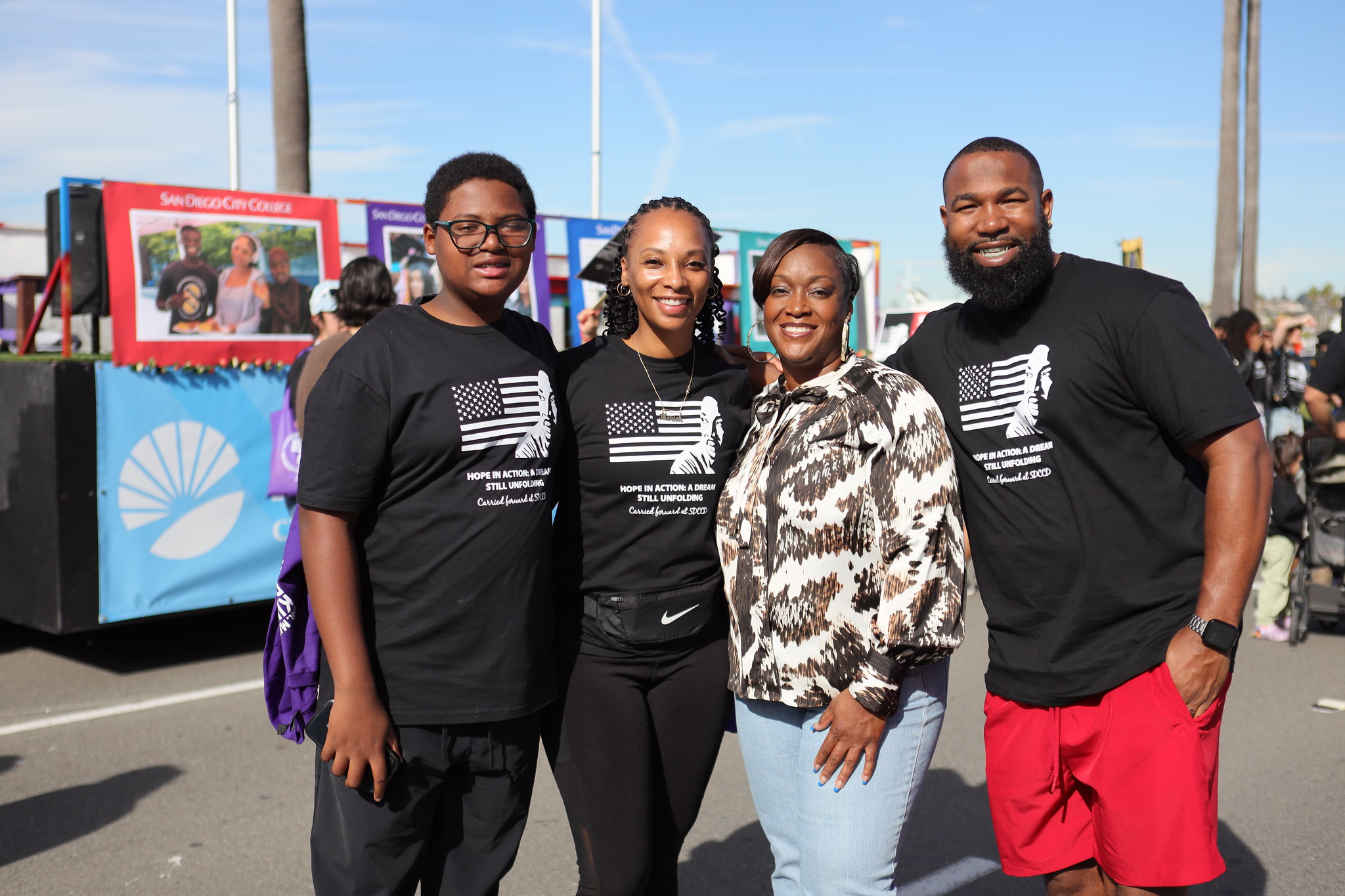 Four parade-goers take a group photo.