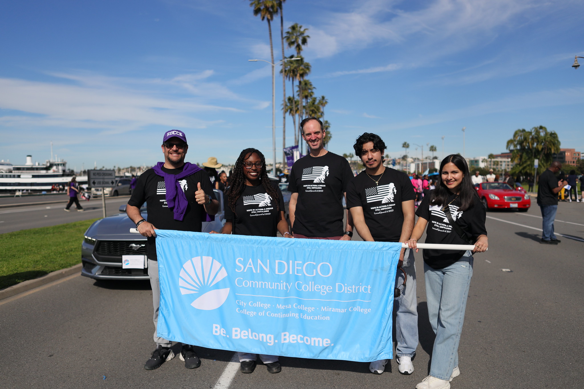 SDCCD Chancellor Gregory Smith the the four student trustees holding a district banner.