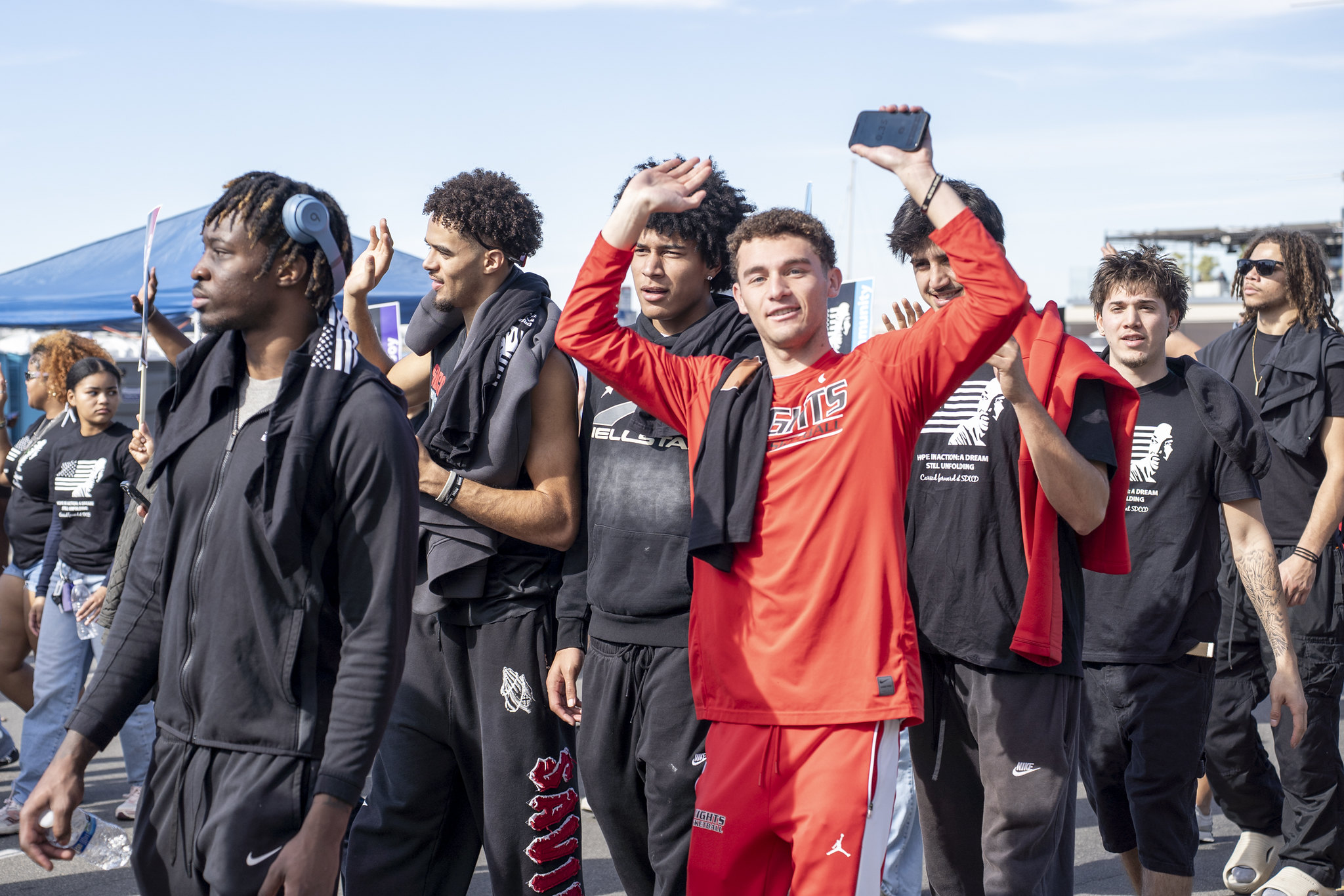 Seven City College men's basketball players walking in the parade.