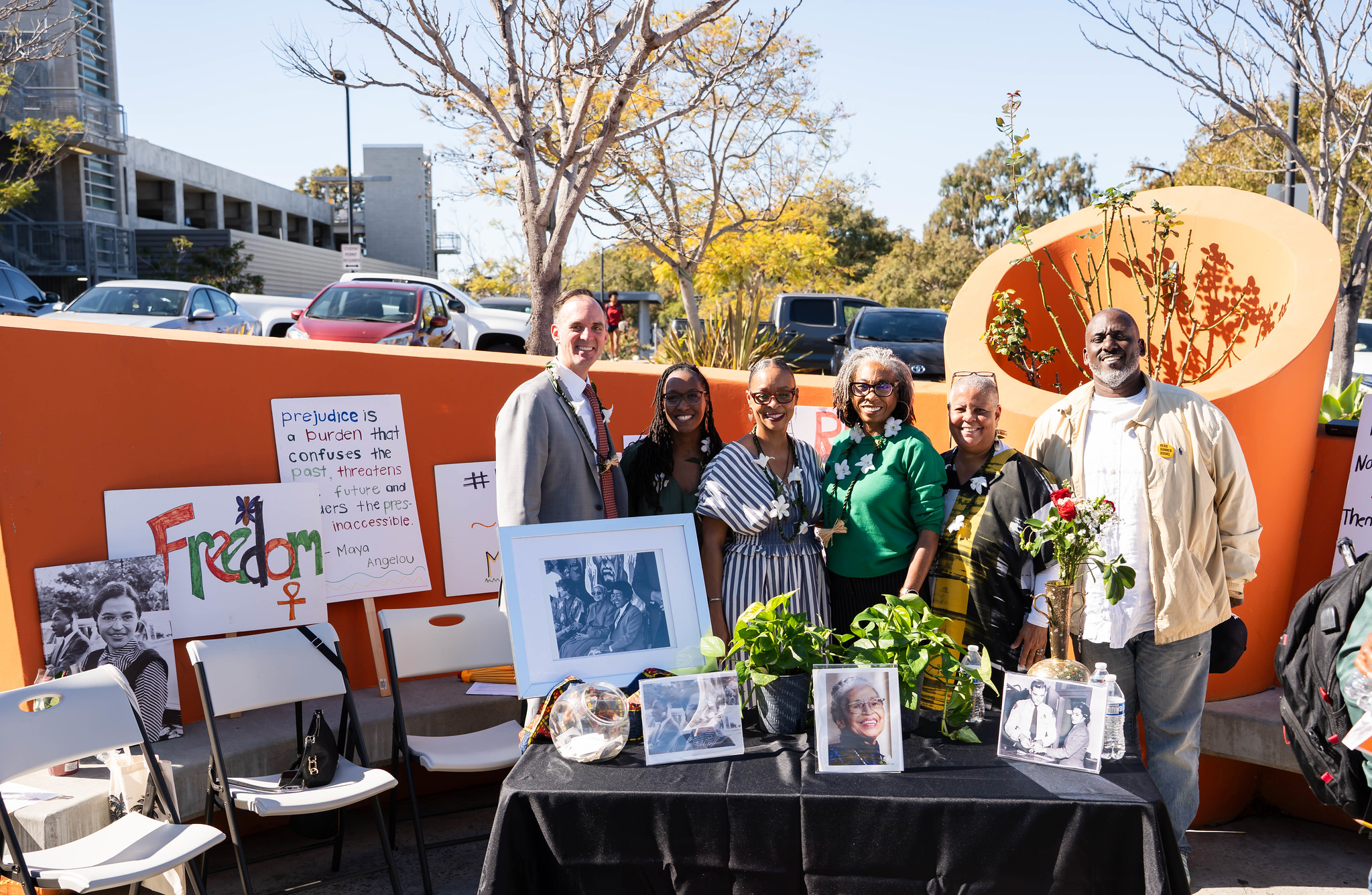 
Six people behind a table of photos from Rosa Parks' visit to Mesa College.
