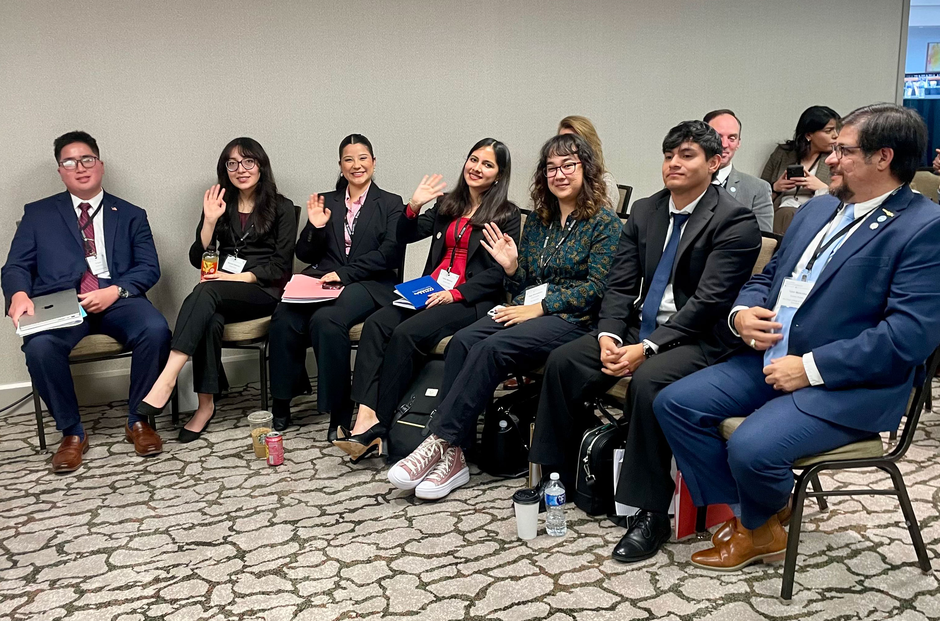 
Four students seated at a presentation
