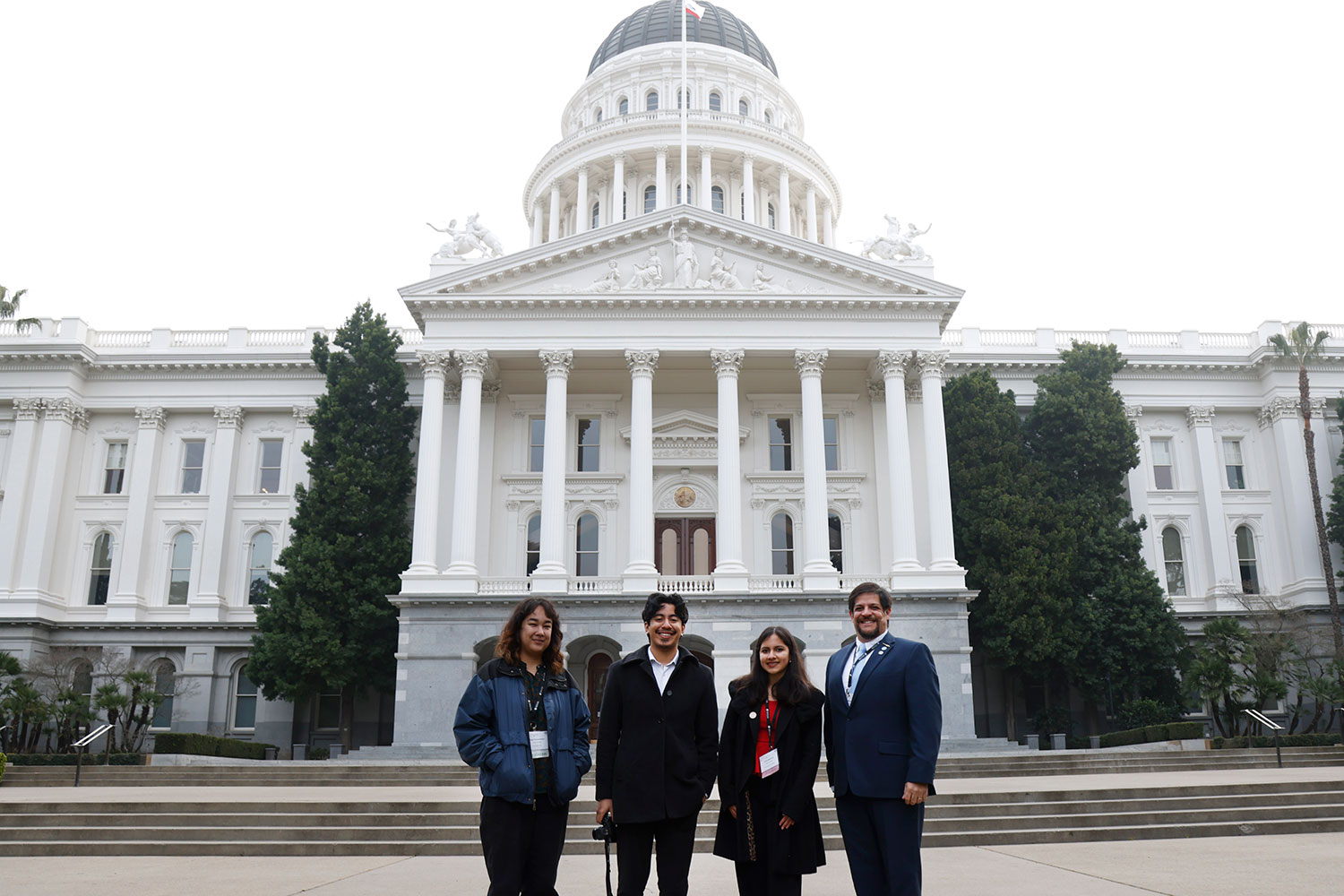 
Four student leaders in front of the Capitol Building in Sacramento.
