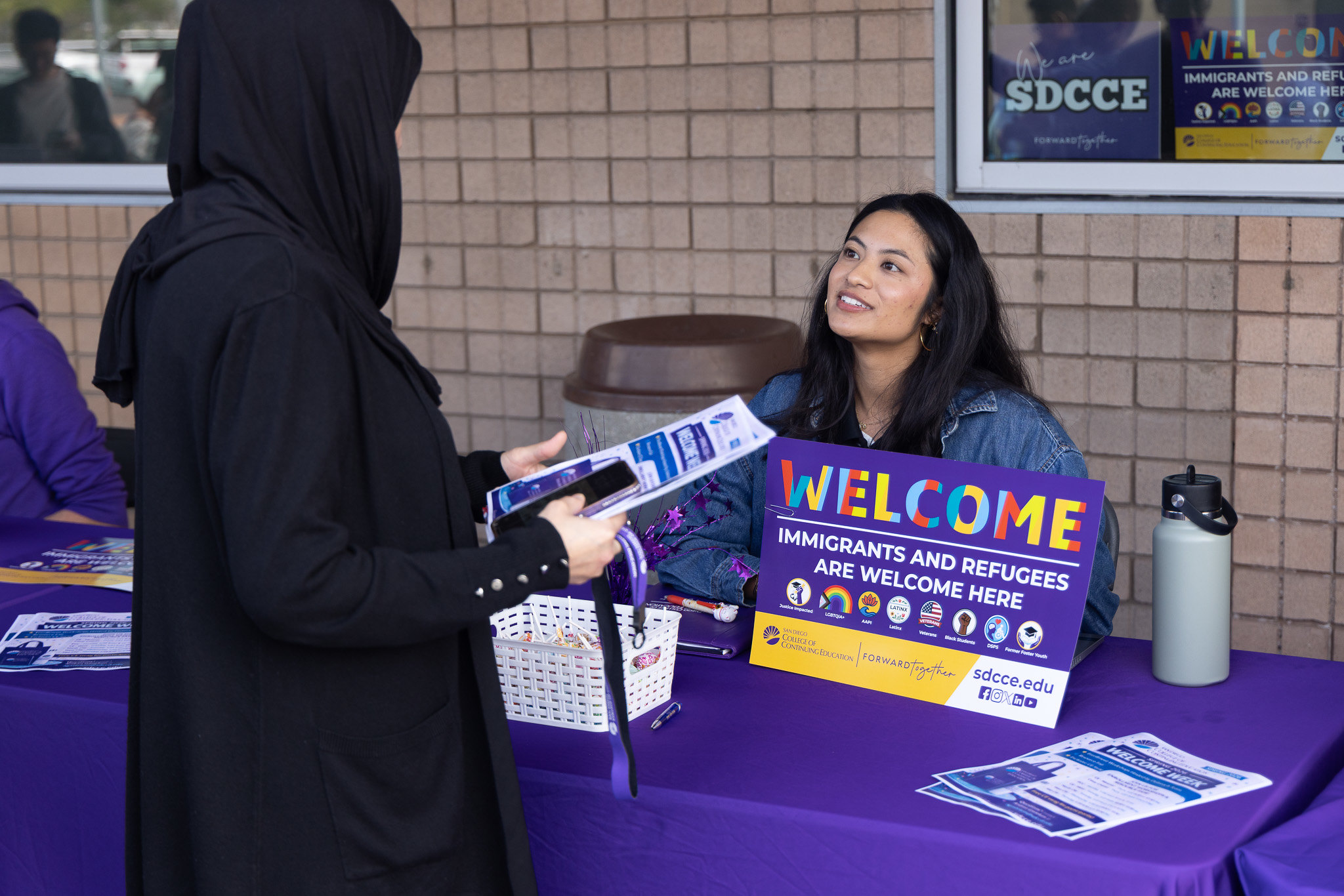 
A lady working at a welcome table at College of Continuing Education.
