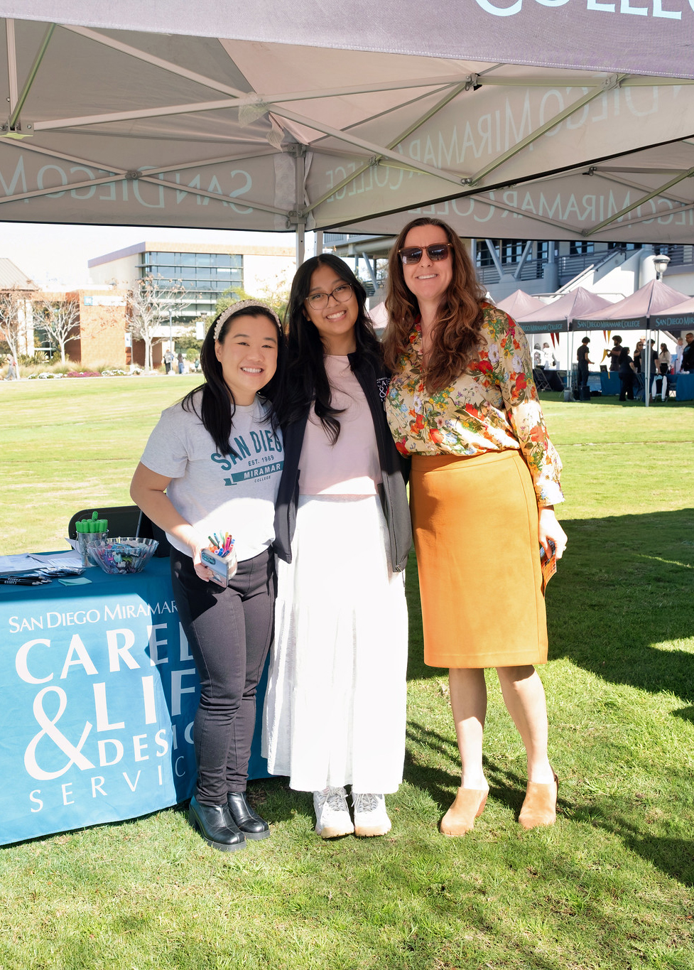 
Three ladies at a Miramar College welcome tent.
