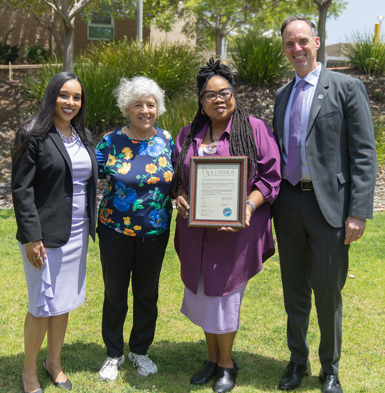 A lady holding a framed proclamation with College of Continuing Education President Tina King, Trustee Maria Nieto Senour and Chancellor Gregory Smith.&nbsp;