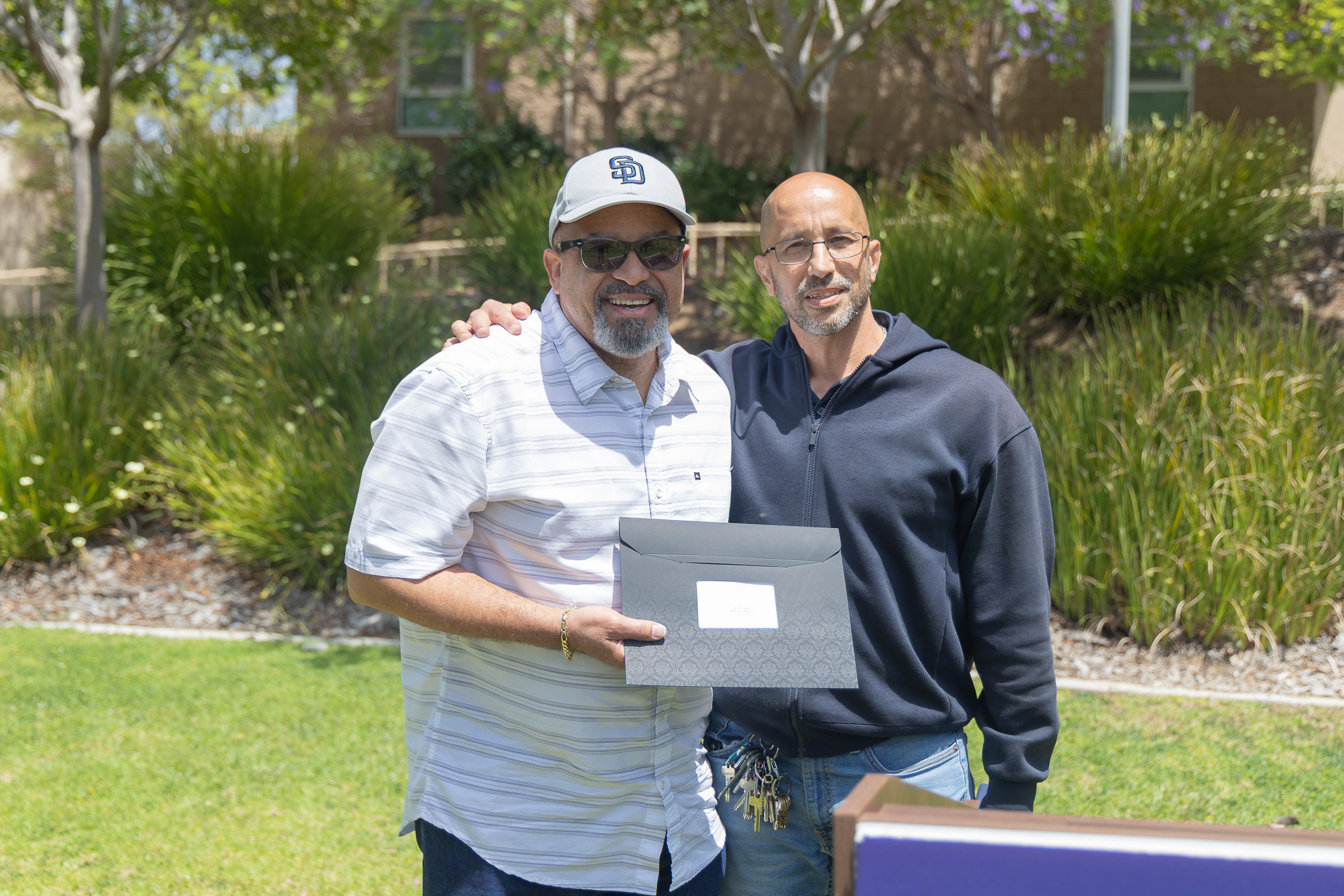 Two men at College of Continuing Education's event. One is holding his service certificate.&nbsp;