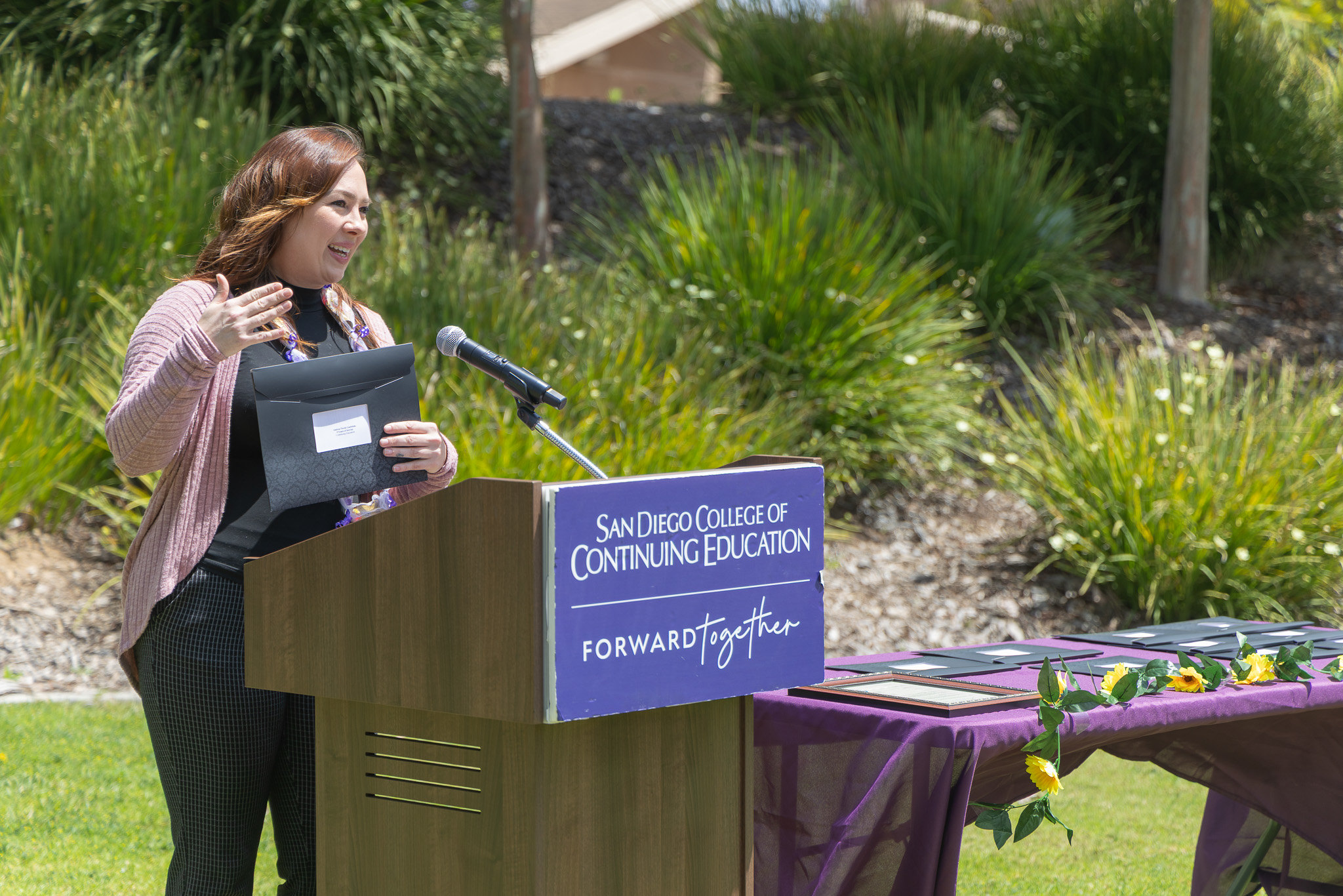 A person speaks at a podium after receiving her service certificate.&nbsp;