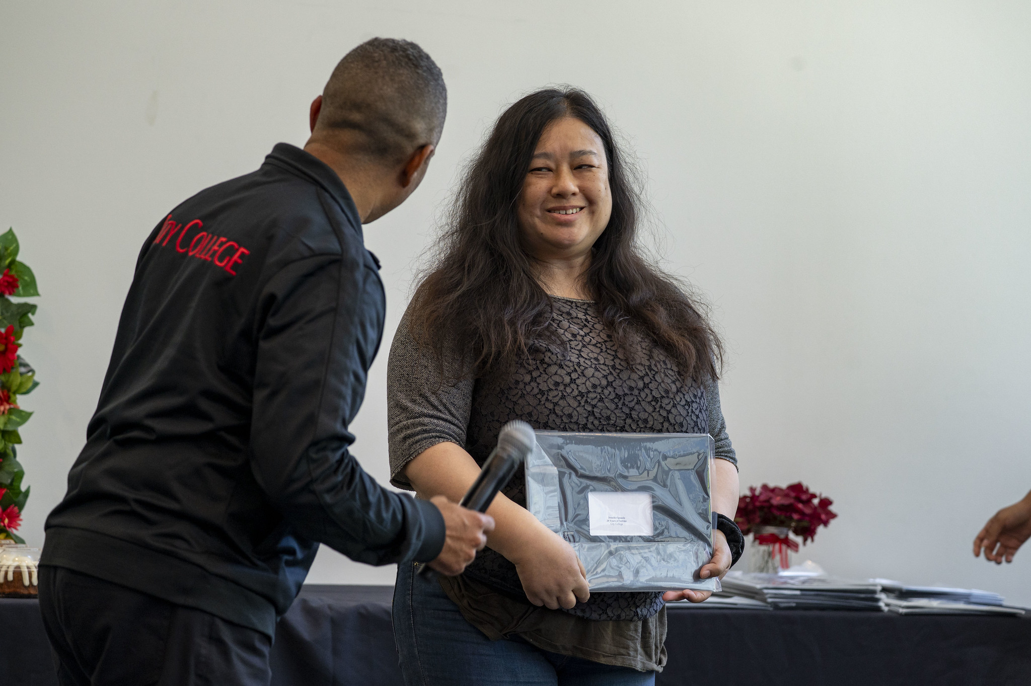 A City College employee receives her service certificate.