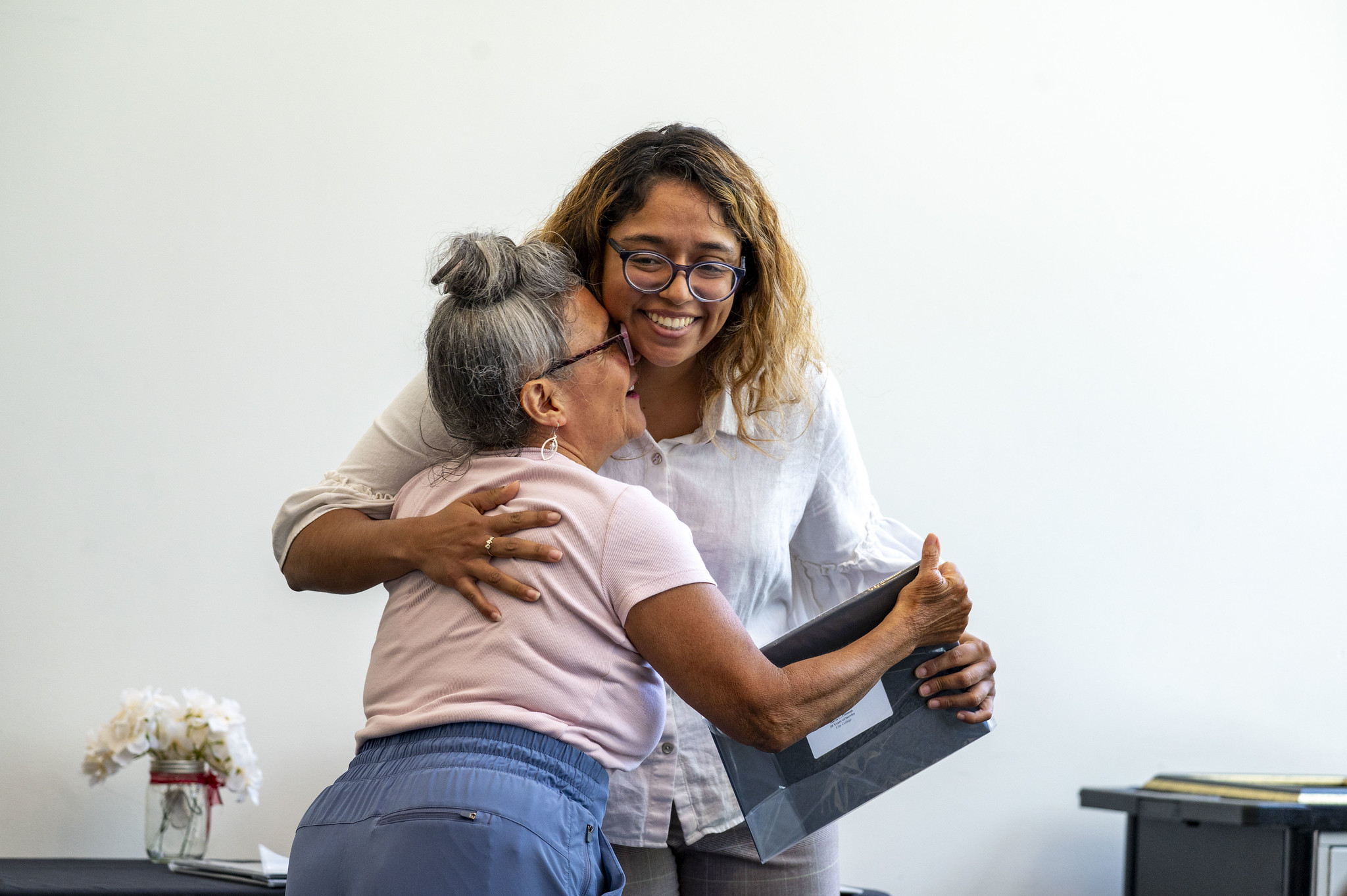 A City College employee gets a hug as she receives her service certificate.