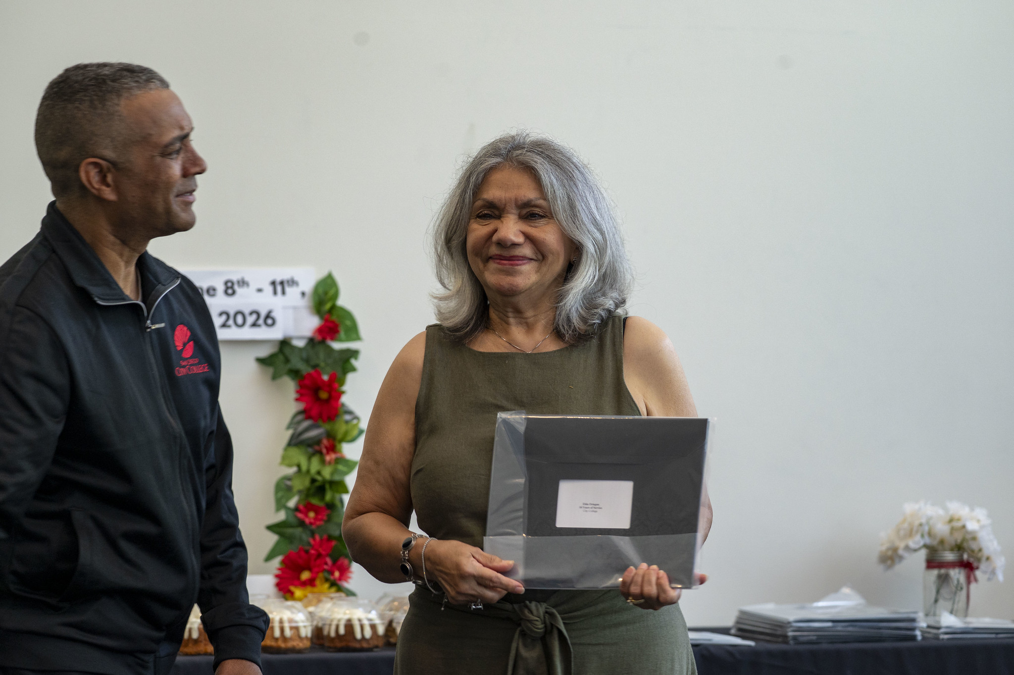 A City College employee receives her service certificate.