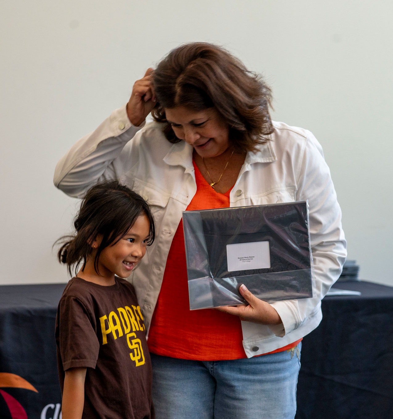 An employee with a little girl receives a certificate for service.