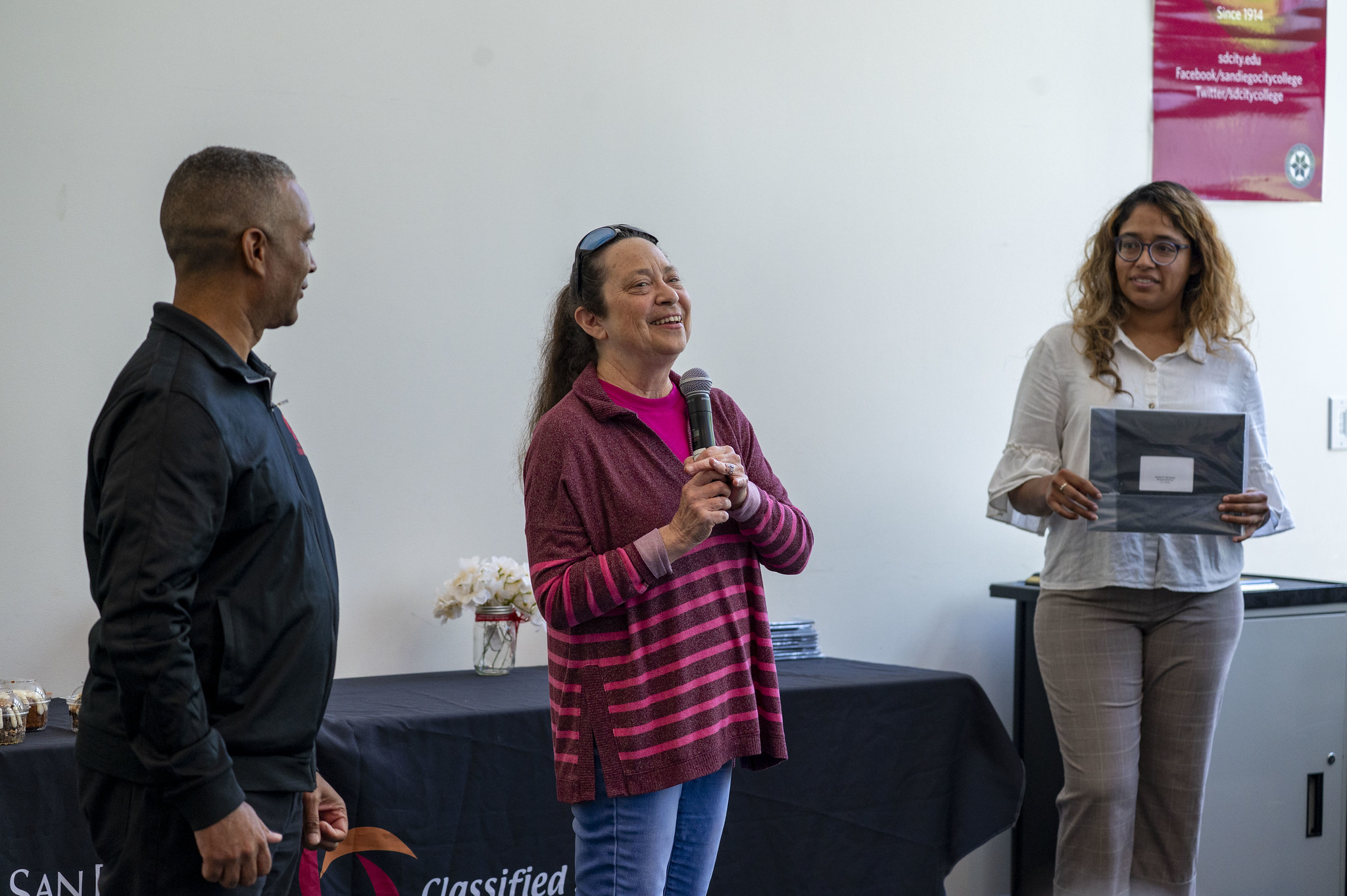 City College President Ricky Shabazz looks on while an employees speaks to the audience before receiving a service certificate.&nbsp;