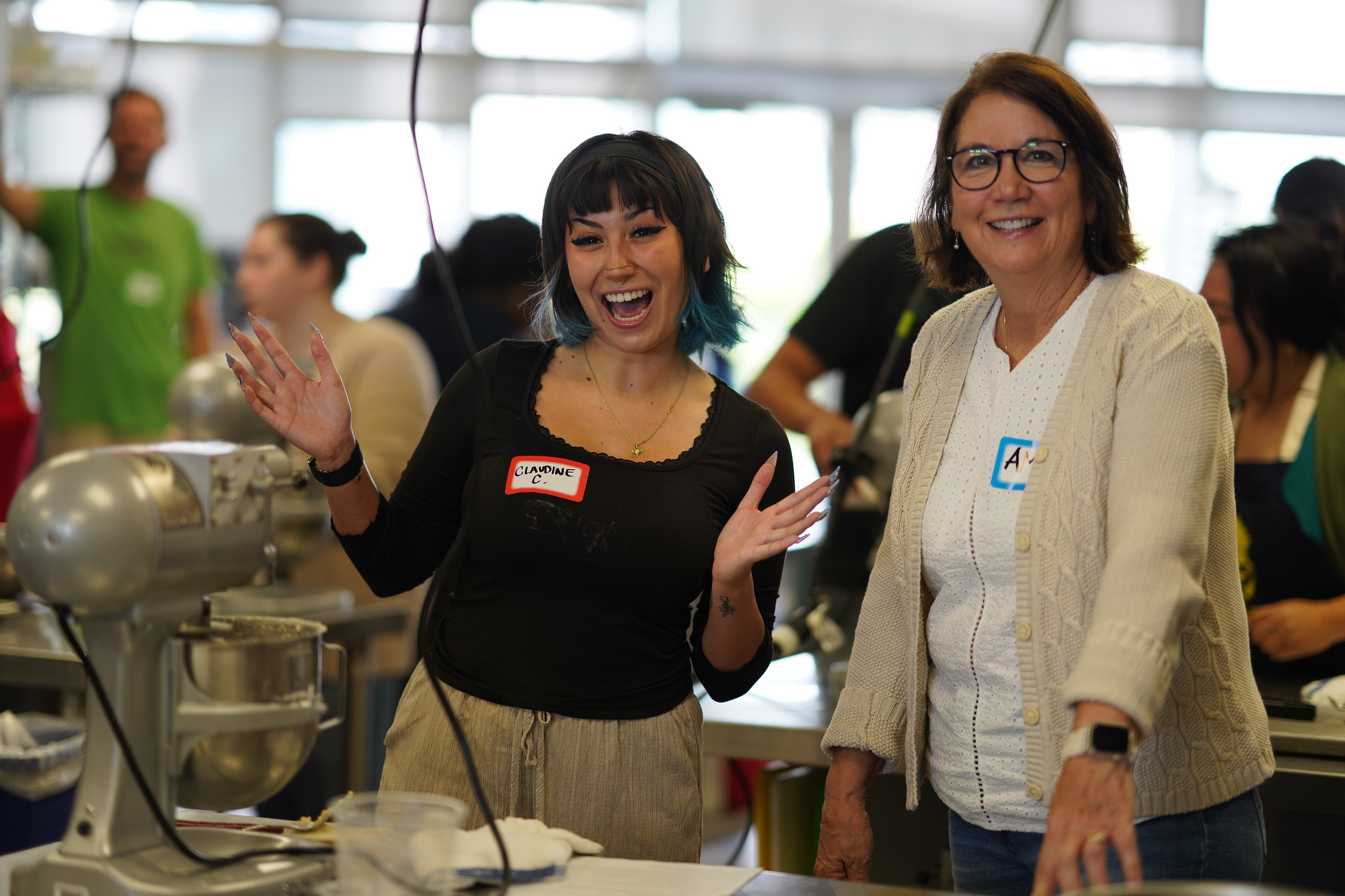 Two employees at a Mesa&nbsp; culinary station using a mixer.