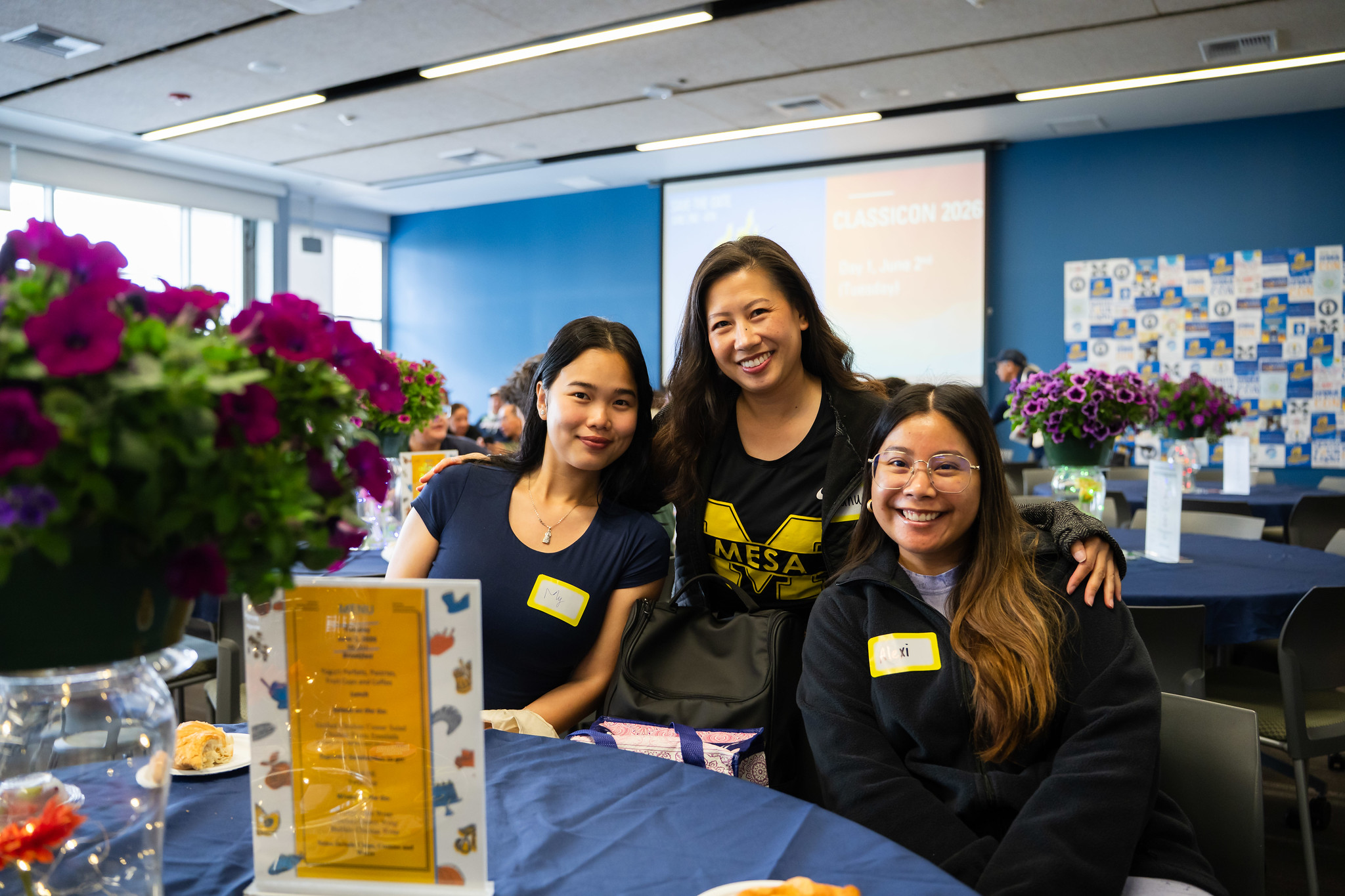 Three employees seated at a table at the Mesa event.&nbsp;