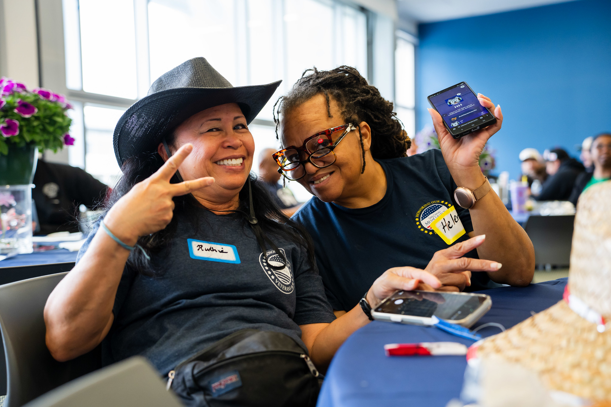 Two employees seated at a table at the Mesa event.&nbsp;