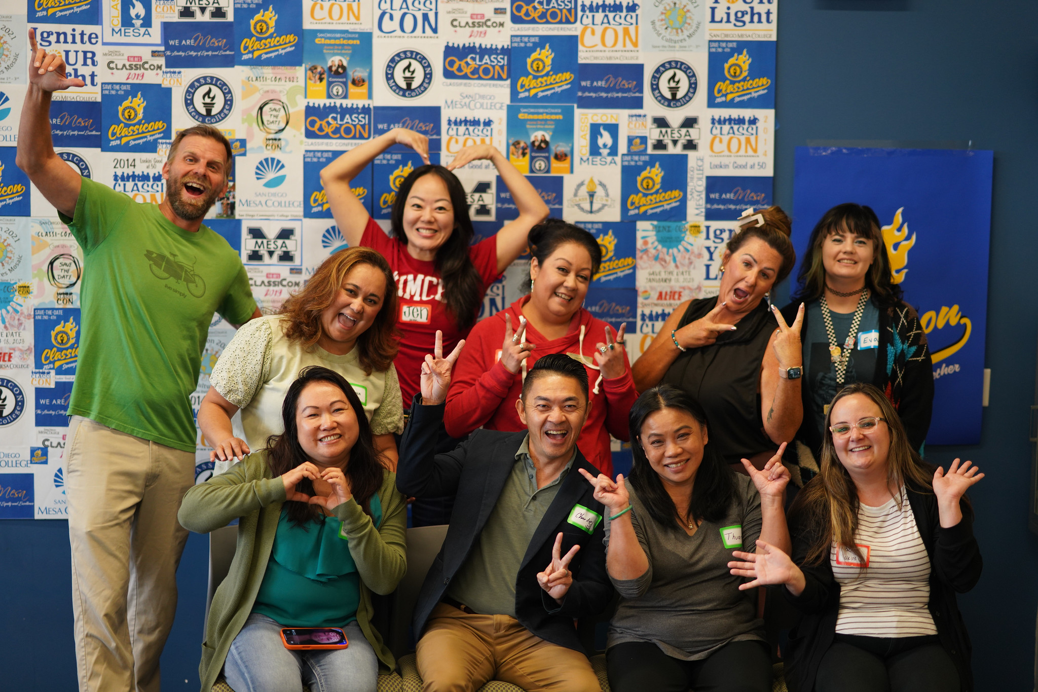 Ten Mesa employees making hearts with their hands and peace signs.&nbsp;