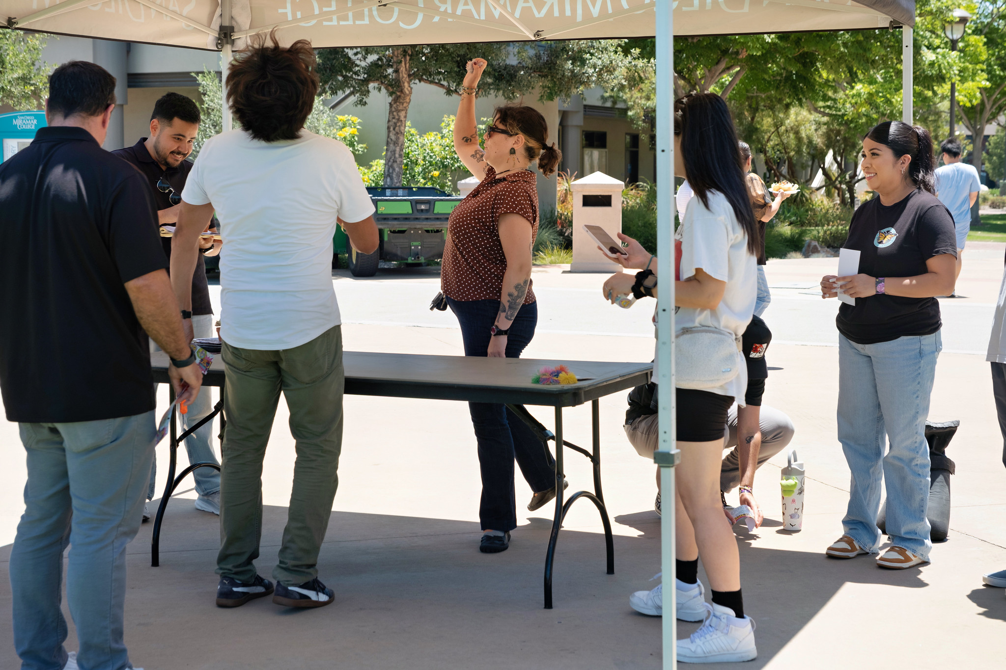 A group of employees gather around a table to play a game.&nbsp;