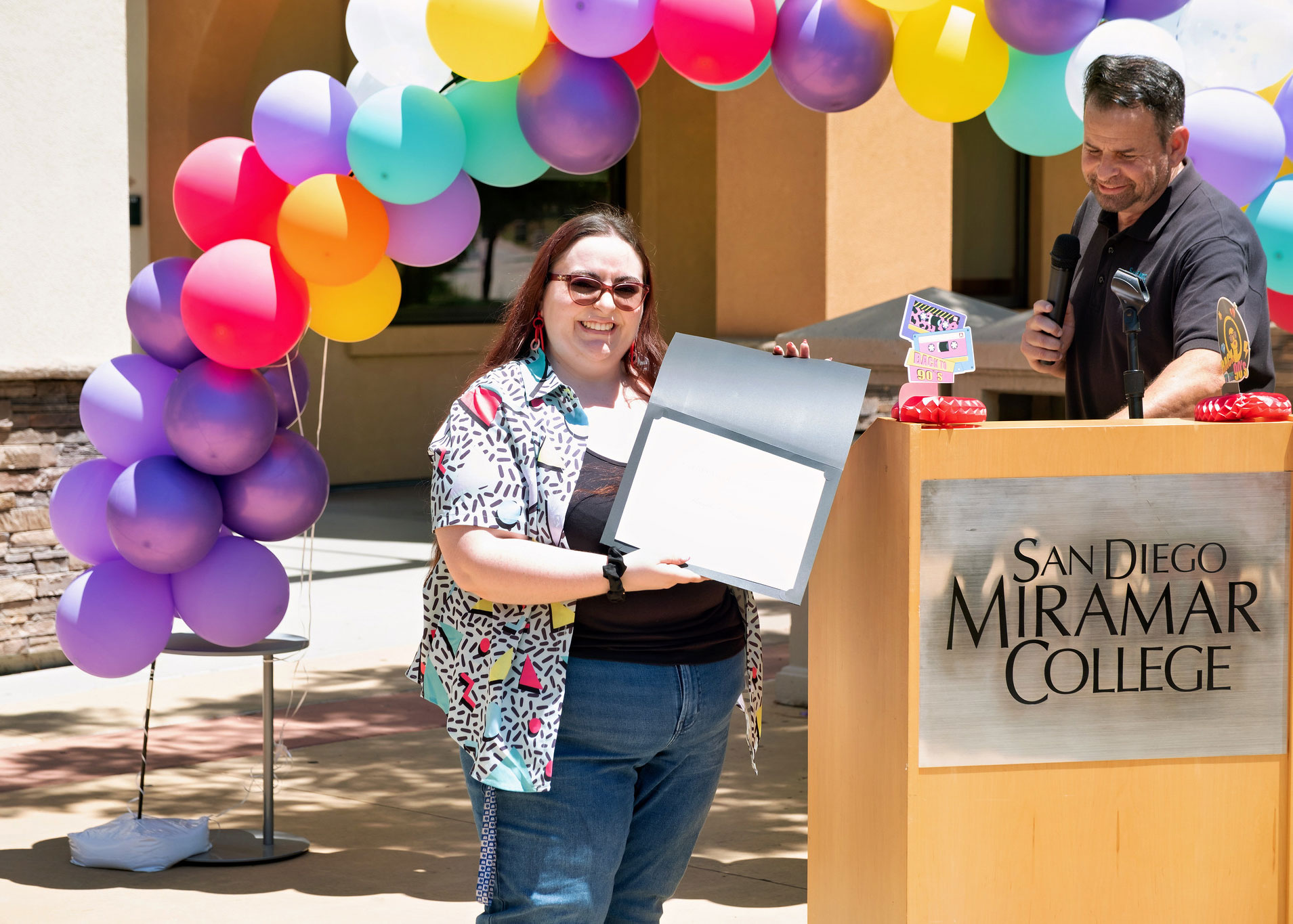 A lady holds up a service certificate.