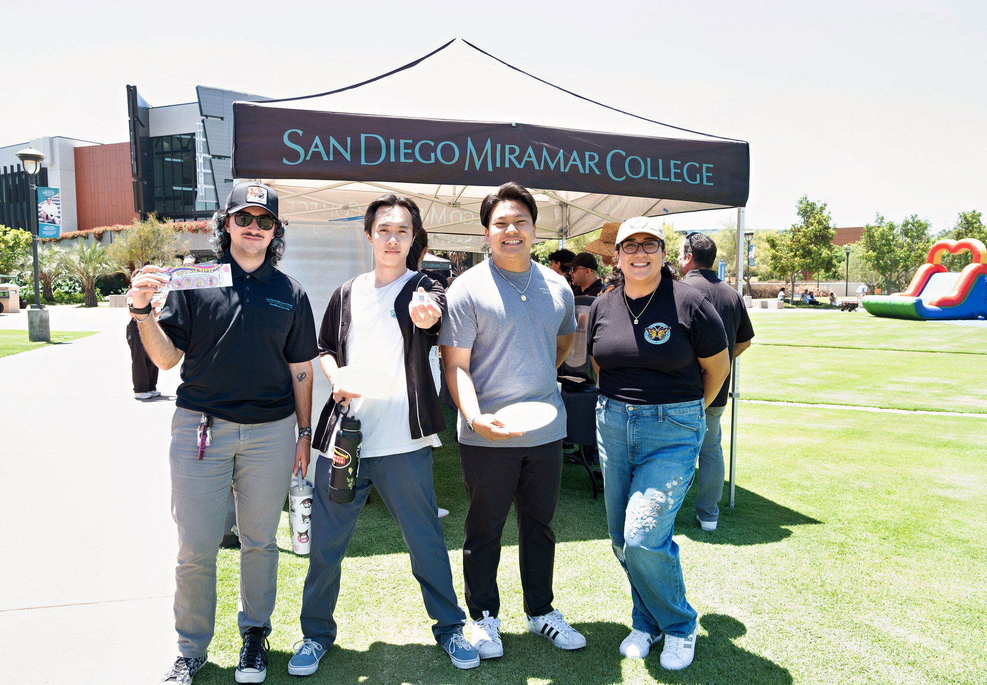 Four employees show off carnival prizes from Miramar's event.