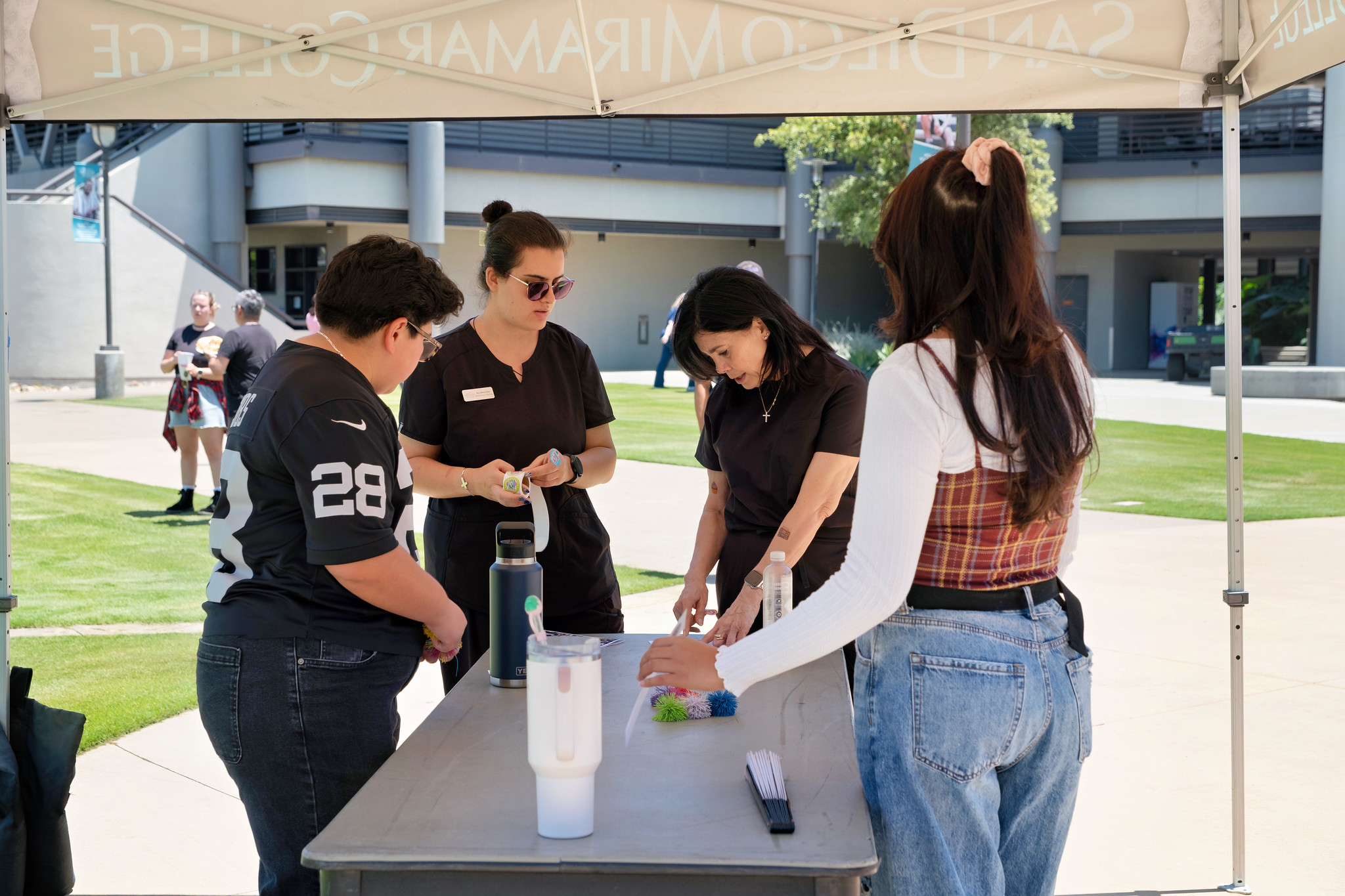 Four Miramar employees gather around a table to play a game.&nbsp;